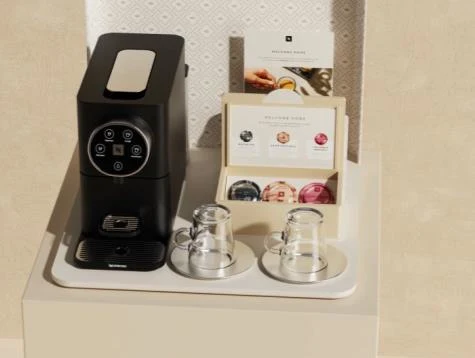 Giorno Mini machine with a capsule display and cups in a compact coffee setting